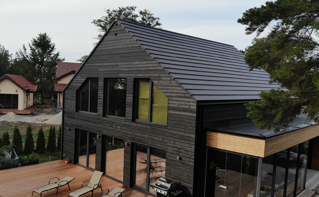 Nybygget sort træhus med integrerede solceller på taget